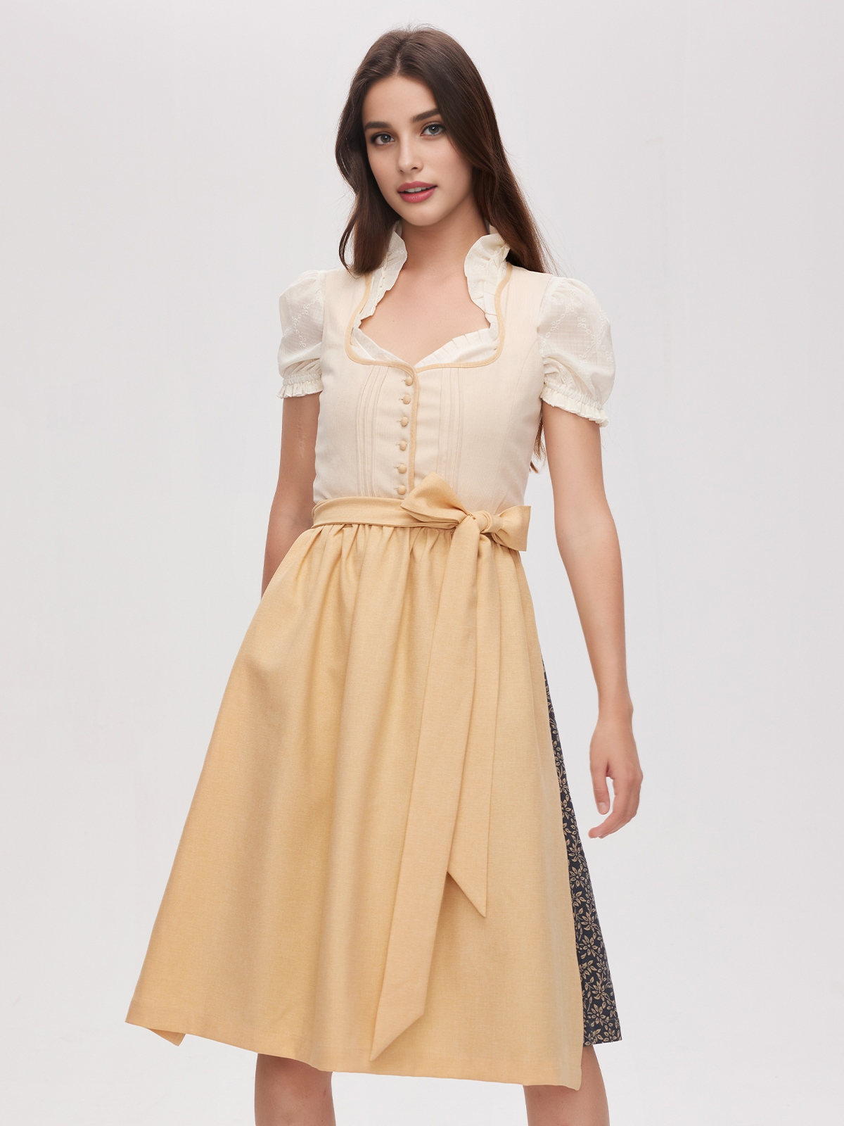 Ein elegantes gelbes Dirndl mit passender Bluse und Schürze